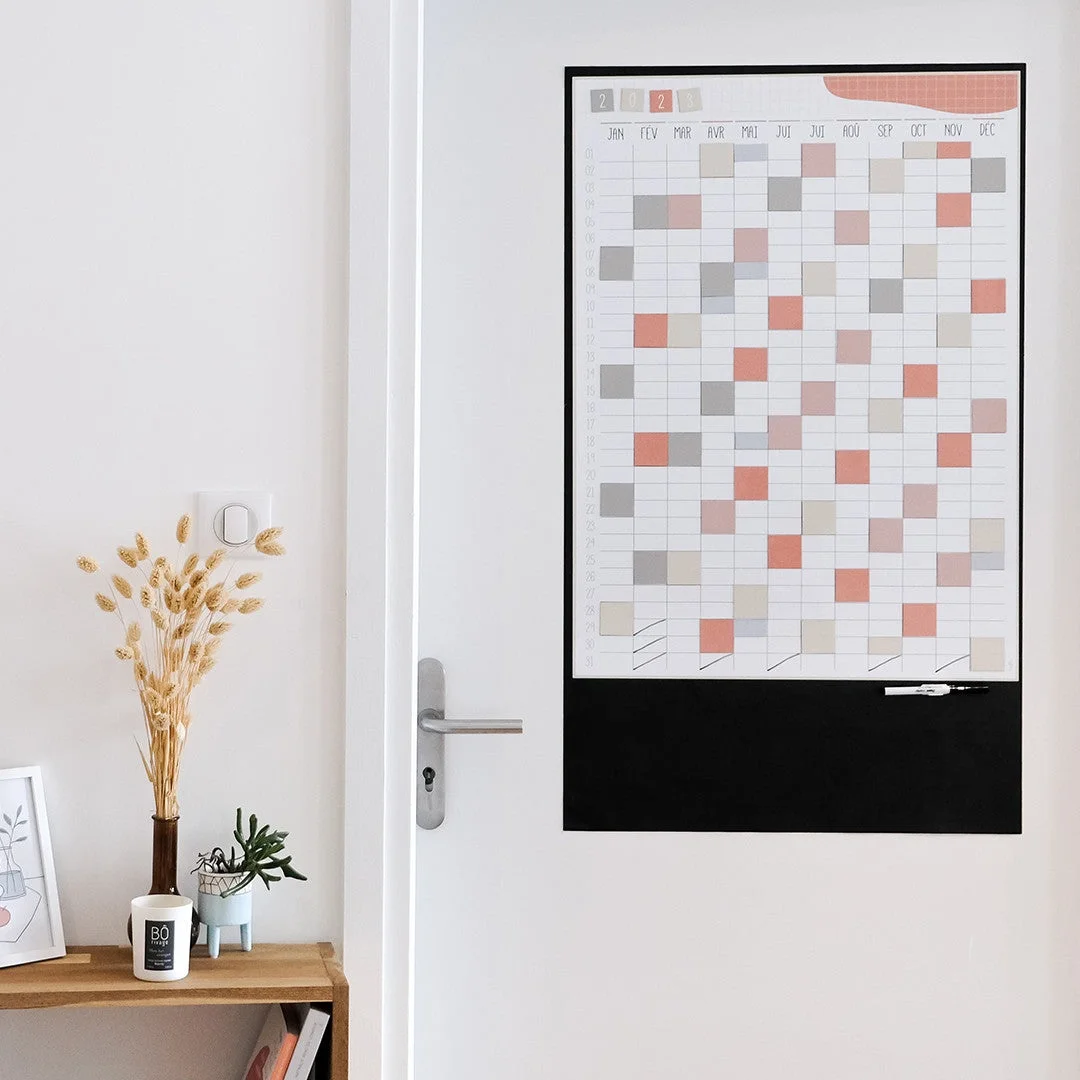 Calendrier mural magnétique Ferflex terracotta avec cases colorées et tableau noir effaçable.