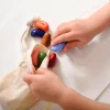 Crayons de cire colorés en forme de pierres, mains d'enfant les manipulant
