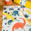 Set de table Dinosaure Annikids avec motifs colorés orange, jaune, bleu et plantes.