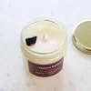 Bougie Maison hantée blanche avec pierre obsidienne noire sur cire, couvercle doré.