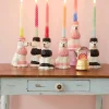 Bougies spirales colorées allumées dans supports en forme de caniche rose et noir.