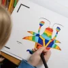 Enfant coloriant un dessin animé arc-en-ciel dans cahier Blink Book Il était une fois... La vie