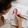 Enfant coloriant la Joconde avec un crayon dans cahier Blink Book Léonard De Vinci.