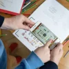 Mains tenant un smartphone affichant animations du cahier de dessin animé Blink Book Les mille et une nuits