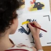 Enfant coloriant un dessin animé de Pédro le corbeau avec crayon rouge, Blink Book.
