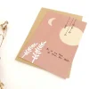 Carte A6 rose "Tu es ma lune" avec lune, étoiles suspendues et feuillages blancs
