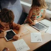 Deux enfants dessinant sur tablettes avec cartes à dessins d'animaux noir et blanc.