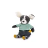 Chien Puce musical en peluche noire et blanche, tee-shirt vert à pois, pantalon bleu.
