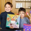 Deux garçons tenant un coffret coloré Chefclub Kids C'est la fête toute l'année.