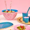 Couverts à salade en mélanine blancs imprimés cerises rouges posé dans saladier rose intérieur bleu