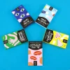 Cinq boîtes colorées de cartes Dilemmes absurdes - Minus, formes et motifs variés.