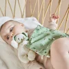 Bébé allongé avec doudou chien vert en tissu doux motifs feuilles Kaloo