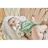 Bébé allongé avec doudou chien vert en tissu doux motifs feuilles Kaloo