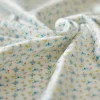 Tissu blanc avec petits motifs bleus et jaunes du doudou raton laveur Gaston Kaloo
