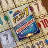 Boîte Flip 7 Soif de vengeance posée sur cartes numérotées colorées étalées bois.