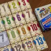 Cartes numérotées colorées de 0 à 13 et boîte du jeu Flip 7 Soif de vengeance