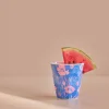 Gobelet en mélanine bleu avec motifs fleurs roses et tranche de pastèque rouge.