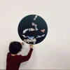 Enfant accrochant magnets sous marin colorés sur cercle magnétique noir "Sous l'océan" Ferflex