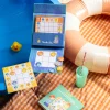 Jeu magnétique Sudokid avec planches illustrées, jetons ronds colorés, sur tissu orange à carreaux.