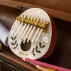 Kalimba ronde bois beige et bords rouges décor floral noir et blanc Moulin Roty