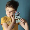 Garçon en t-shirt jaune tenant un robot bleu ciel du kit créatif L'espace