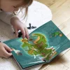Enfant lisant livre ouvert avec carte colorée de l’île imaginaire Peter Pan