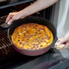 Poêle Cookut 28 cm en métal rouge avec anses bois, flan cuit doré aux raisins.