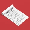 Feuille blanche déroulée avec texte noir sur fond rouge, livre jeu KIMOMÖ