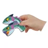 Main d'enfant tenant deux pièces magnétiques en bois représentant têtes de dragon vert et violet, Magnéti'book Dragons Janod.
