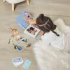 Enfant allongée jouant avec Magnéti'book Métiers Janod et magnets colorés en bois.