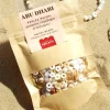 Mélange perles heishi blanches et beige, breloques coquillages, sachet kraft.