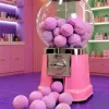 Distributeur rose rempli de mini billes de bain effervescentes violettes Berry Bloom Nailmatic.
