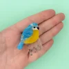 Mini pince à cheveux Mésange, oiseau bleu et jaune en plastique translucide.