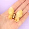 Mini pince à cheveux papillon jaune transparent en plastique, tenue dans une main.