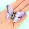 Mini pince à cheveux papillon violet transparent avec points noirs, tenue dans une main