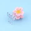 Mini pince à cheveux Sakura avec fleur rose et centre jaune, plastique transparent.