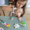 Fille peignant des décorations de Noël en plâtre blanc avec peinture colorée Mako Moulages