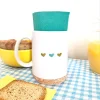 Mug blanc Pop Merci avec motifs cœurs, couvercle et base en liège, serviette bleue