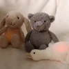 Peluche lumineuse Lou ours gris avec lapin beige et canard blanc allongé