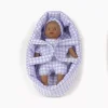 Poupon Minis Pia peau foncée aux yeux clairs dans couffin Vichy violet lilas Minikane.
