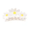 Pince à cheveux plastique translucide avec trois grosses pâquerettes blanches et centres jaunes.