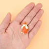 Pin's Renard orange et blanc en émail posé sur une main ouverte beige