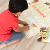 Enfant posant des stickers animaux colorés sur poster La savane Poppik beige.