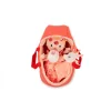 Poupée Bébé Lena en tissu avec motifs rouges, couffin corail et doudou blanc.