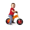 Enfant souriant sur draisienne Little Bikloon bois orange et roues rouges.