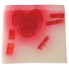 Savon carré transparent rose et blanc avec cœur rouge et petits morceaux rouges noirs