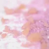 Granulés roses translucides et gros cristaux rose pâle du sel de bain crépitant Rose Nailmatic.