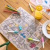 Set en silicone à colorier Les Popipop avec 5 feutres colorés sur table bois.