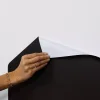 Main féminine posant un coin du tableau magnétique Ma ville Ferflex noir autocollant.