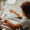 Enfant dessinant un oiseau en noir sur tablette à dessin Animaux Kidydraw-Mini rouge.